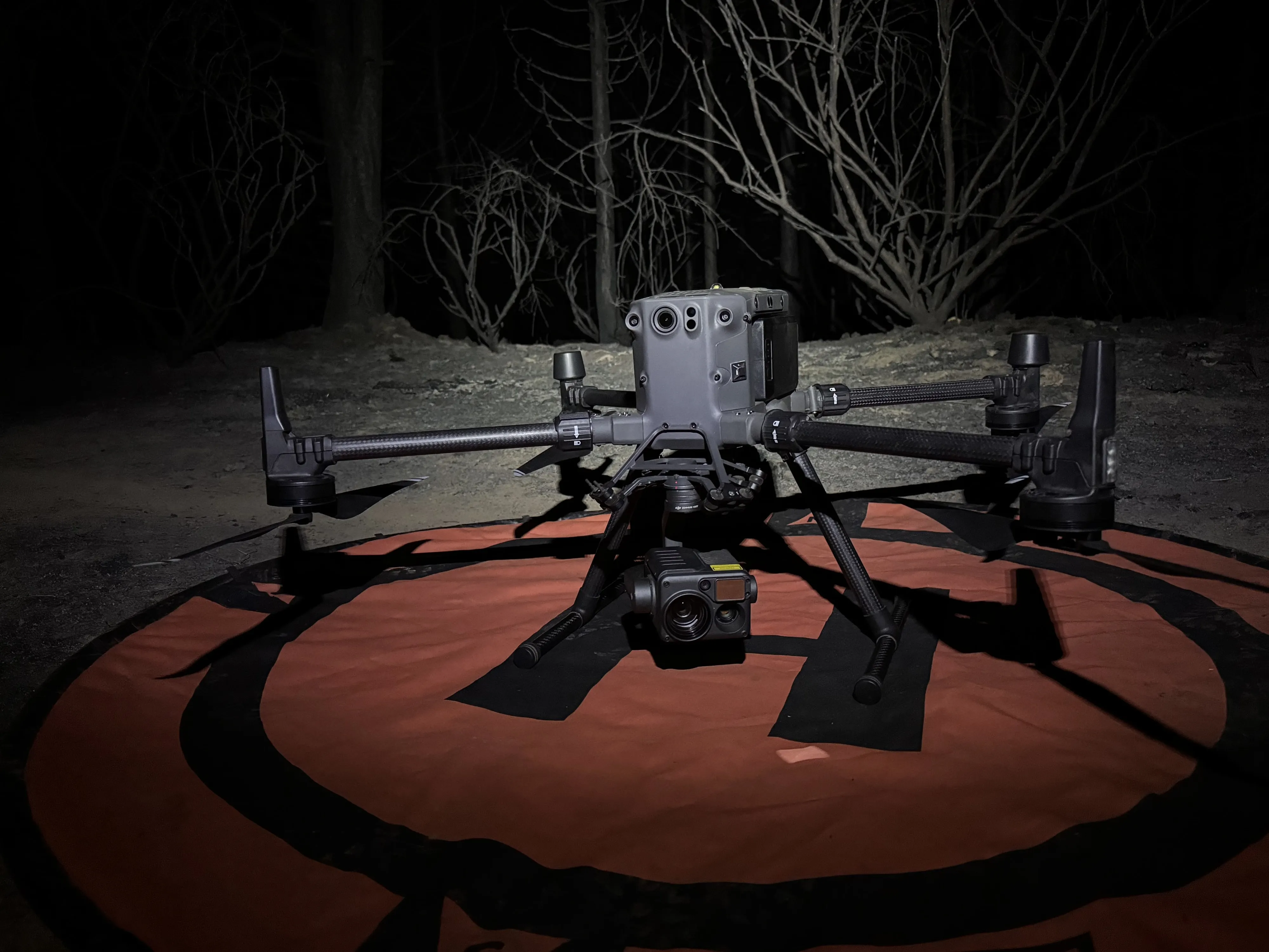 The Matrice 300 with the H20T thermal camera on its landing pad at night.
