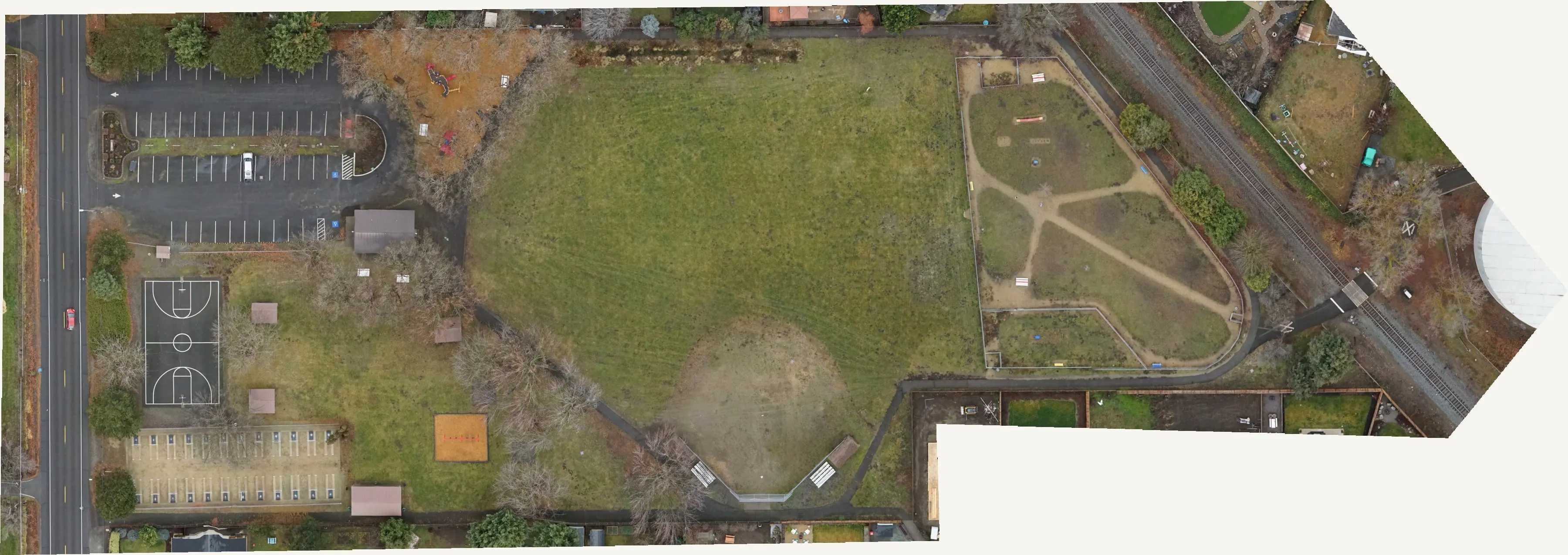 Winter orthomosaic of a city park with ball fields, a playground, a parking lot, and bare trees.