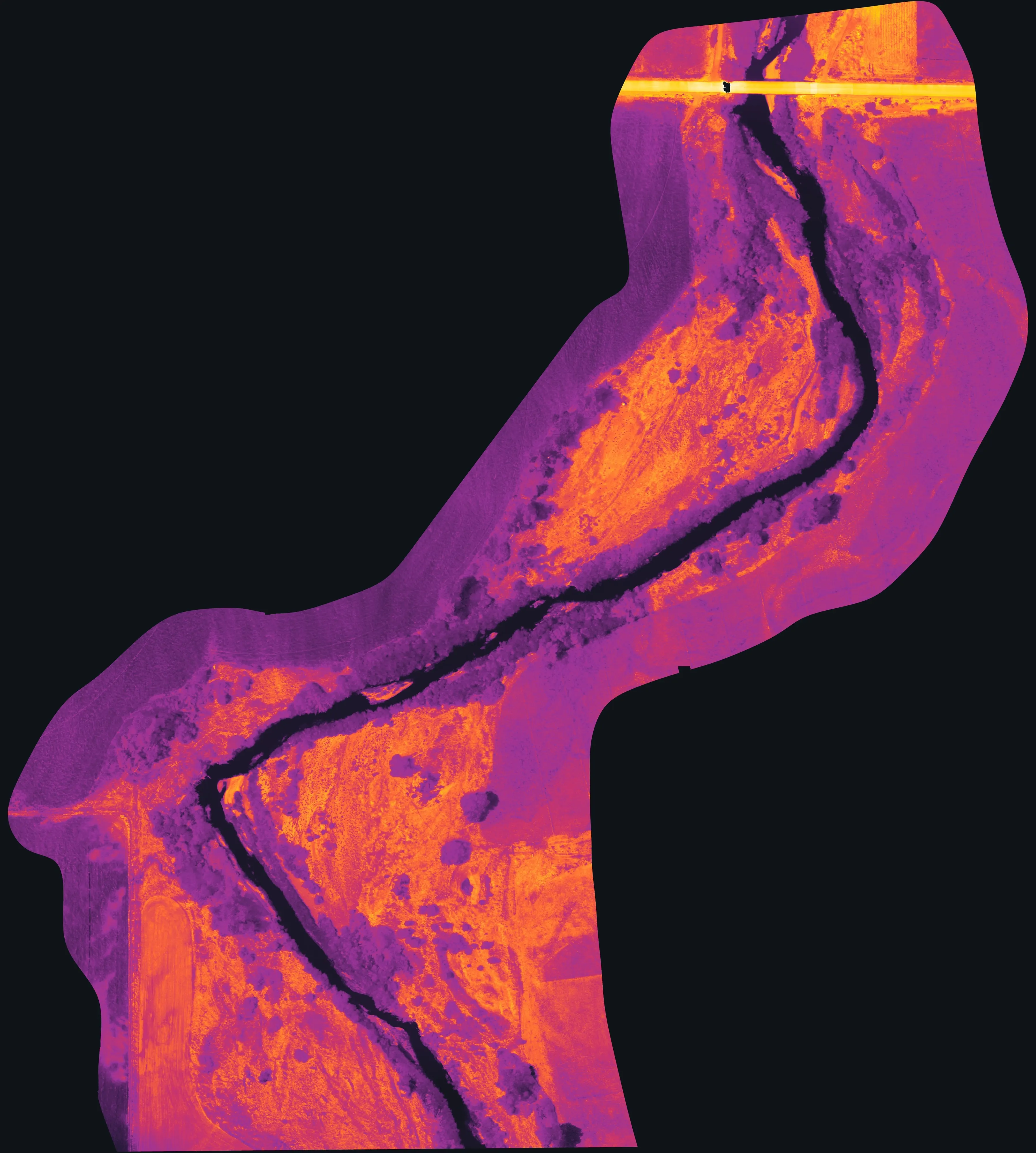 Thermal orthomosaic of a river reach: the channel reads dark and cool, gravel bars and open ground glow orange and yellow.